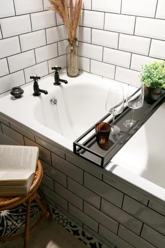 a bathroom sink with two wine glasses on a shelf at NEW LUXURY for 2024 - Central Plymouth House - Sleeps 10 - Access to Plymouth Town - Close to The Barbican - Pets welcome - Parking Available - By Luxe Living by Sophia in Plymouth