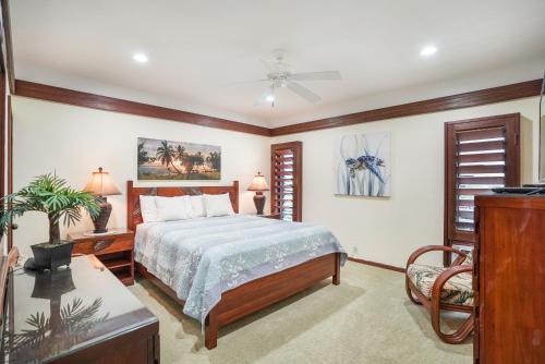 カパアにあるOceanfront Escape with Lush Garden Access at Lanikai 122のベッドと天井扇風機のある寝室