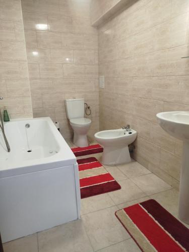 a bathroom with a tub and a toilet and a sink at Dimitra in Piatra Neamţ