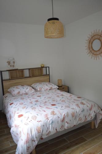 a bedroom with a bed with a bedspread with flowers at Clair Matin - Maison avec jardin privatif in Crécy-en-Ponthieu