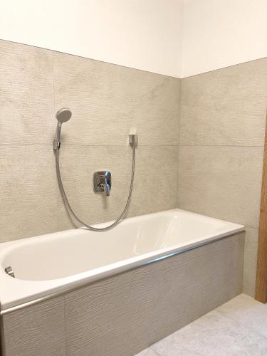 a bath tub in a bathroom with a shower at Ferienwohnung Kühar in Maishofen
