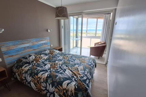 une chambre avec un lit et une vue sur l'océan dans l'établissement T3 Duplex Vue mer accès Plage, à Dosse Gros