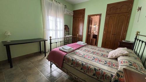 a bedroom with a bed and a table and a window at Casa Santa María by CasaTuristica in Ronda