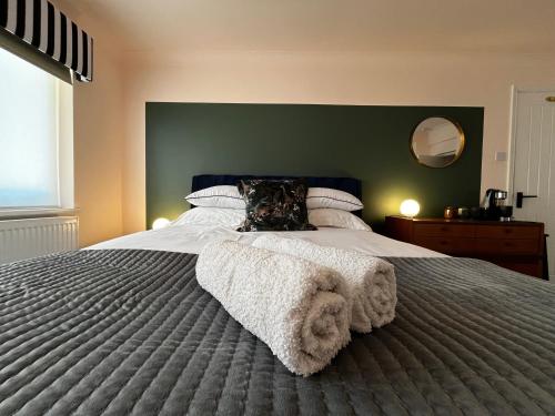 a bedroom with a large bed with a green wall at Luxury Room in the New Forest in Eling