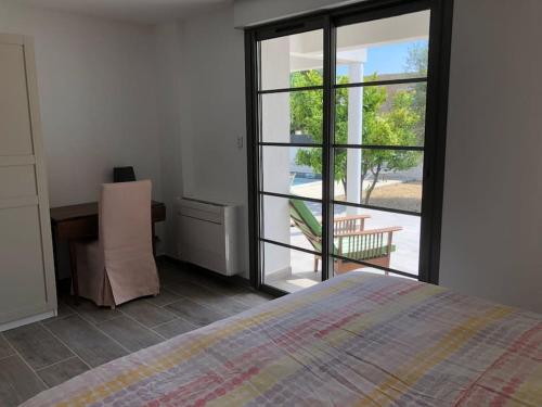 ein Schlafzimmer mit einem Bett und einer Glasschiebetür in der Unterkunft Villa MAJOULIÈRE in La Ciotat