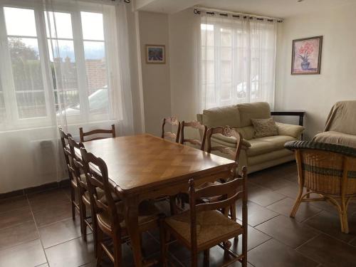un salon avec une table, des chaises et un canapé dans l'établissement Grande maison au centre Ville des Andelys, aux Andelys