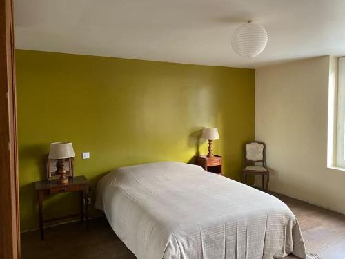 - une chambre avec des murs verts et un lit avec deux lampes dans l'établissement Grande maison au centre Ville des Andelys, aux Andelys