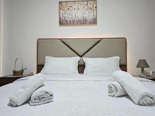 a bedroom with a white bed with towels on it at Superb 1 bedroom in the best zone of the city. in Ferizaj