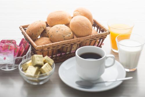 a basket of bread and a cup of coffee and milk at Sotetsu Fresa Inn Chiba Kashiwa in Kashiwa