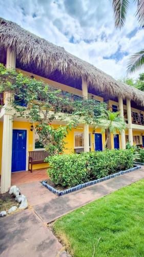 a yellow building with a bench in front of it at Hotel Cafe del Sol in Monterrico