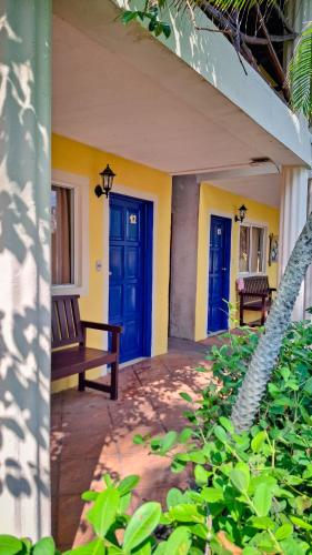 a porch with blue doors and a bench at Hotel Cafe del Sol in Monterrico