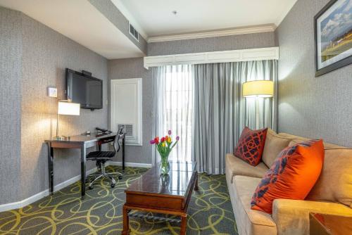 a living room with a couch and a desk in a hotel room at Best Western Plus Dixon Davis in Dixon