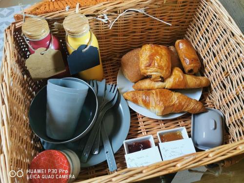 a basket filled with bread and pastries on a table at La roulotte des nuits étoilées du moulin in Sainte-Orse