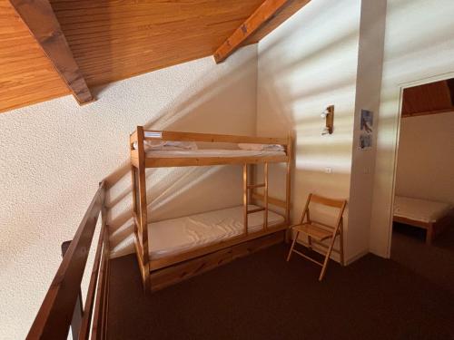Ce lit superposé se trouve dans un dortoir doté d'une chaise. dans l'établissement Charmant Duplex à Autrans, 6 pers, 45m², Proche Pistes et Commerces, Balcon Sud - FR-1-737-58, à Autrans