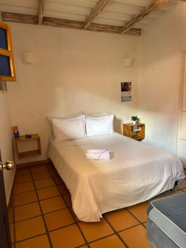 a bedroom with a large bed with white sheets at Zana Hotel Boutique in Bogotá