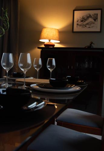 a table with three wine glasses and a lamp at les pies vertes in Andenne