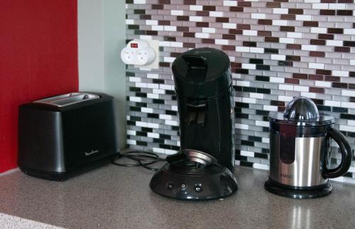 a kitchen counter with a blender and a coffee maker at les pies vertes in Andenne