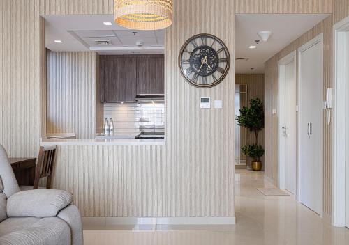 a living room with a clock on a wall at 15BR Serene Escape by Blue Cloud Holidays in Sharjah