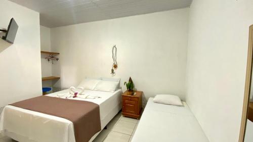 a small bedroom with a bed and a night stand at POUSADA FLORA in Alter do Chao