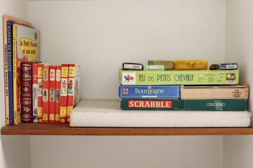 a stack of books sitting on a shelf at Le Petit Clos au coeur de Puligny-Montrachet in Puligny-Montrachet