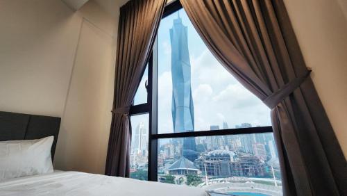 a bedroom with a window with a view of the tallest building at Opus Residences Kuala Lumpur by Infini Suites in Kuala Lumpur