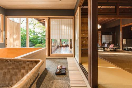 Kyoto Nanzenji Ryokan Yachiyo في كيوتو: غرفة بها أريكة وكتب على الأرض