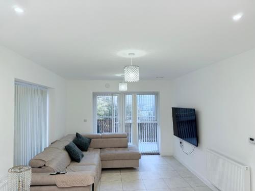 a living room with a couch and a flat screen tv at Sorbus - Flat in West Thurrock