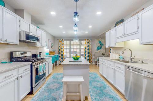 a kitchen with white cabinets and a blue rug at Pretty in Perdido Key in Perdido Key