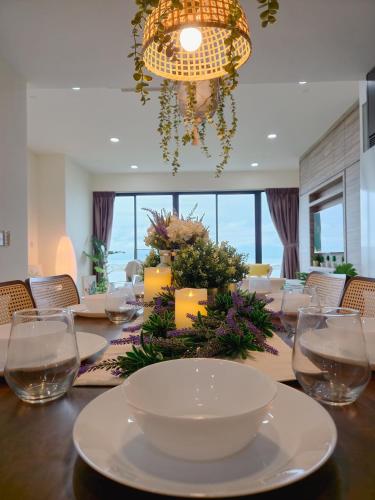 a dining room with a table with glasses and a chandelier at NEW Sunrise Gurney with SEAVIEW 无敌日出海景 in George Town