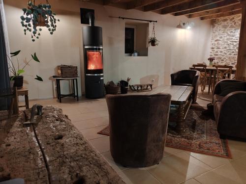 a living room with a wood stove and a table at La Source Du Bonheur Chambres et Table d'Hôtes in Rieupeyroux