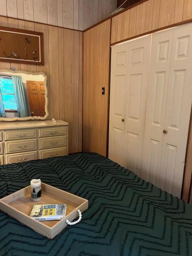 a bedroom with a tray on a bed with a mirror at Cabin in the Clouds in Stanley