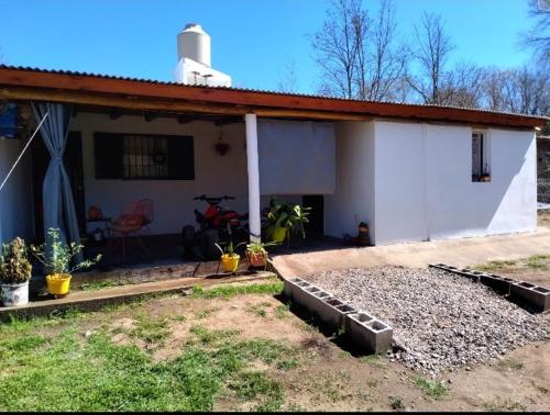 a white house with a patio and a yard at Che Sy ha Che Ru in Cosquín