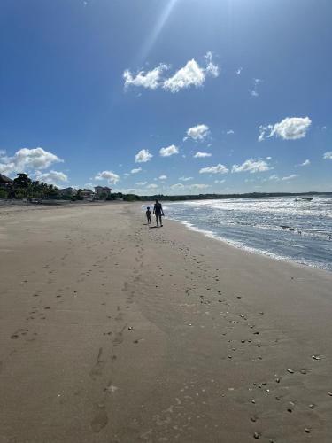 a person and a dog walking on the beach at Tortugas Nest Resort in Miramar