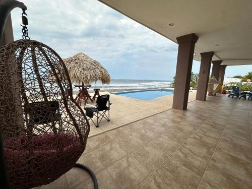 a swing hanging from a house with a swimming pool at Tortugas Nest Resort in Miramar