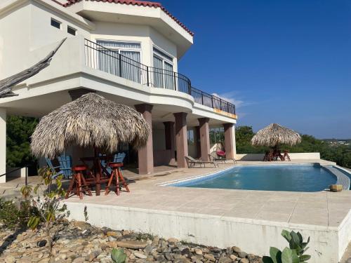 a house with a swimming pool in front of it at Tortugas Nest Resort in Miramar