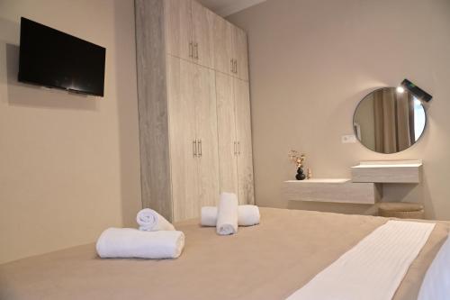 a bedroom with a bed with towels and a mirror at Adel's Elegance Stays in Alexandroupoli