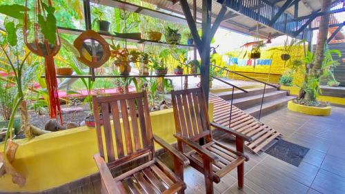 two wooden chairs sitting on a porch with plants at POUSADA FLORA in Alter do Chao