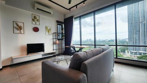 a living room with a couch and a television at Opus Residences Kuala Lumpur by Infini Suites in Kuala Lumpur