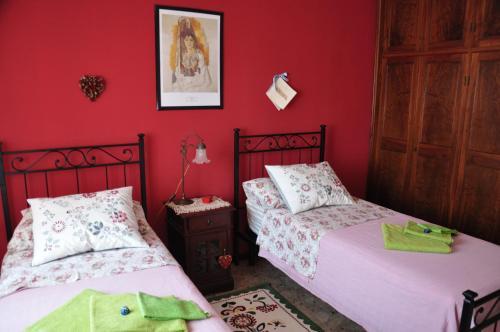 two beds in a room with red walls at Apartment Montebello in Parma