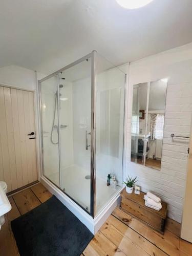 a bathroom with a shower with a glass door at Beautifully Quaint Cottage in Yelling