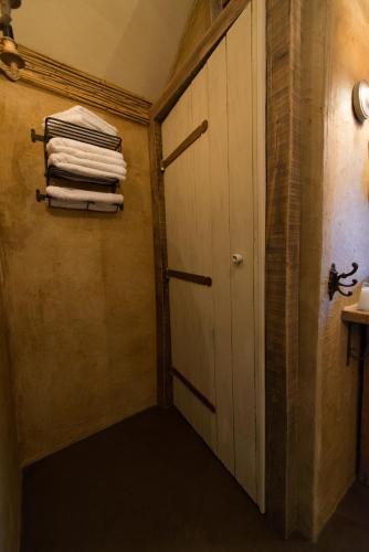 a hallway with a door and some towels at Les Chambres du Vivier, chambres d'hôtes et gîte - à 100m - in Durbuy