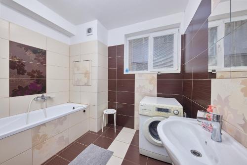 a bathroom with a washing machine and a sink at Relax apartment in Bratislava
