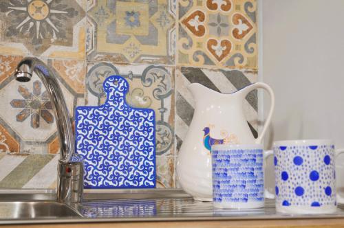a kitchen counter with blue and white vases and a sink at Casa Teresa in Portoscuso
