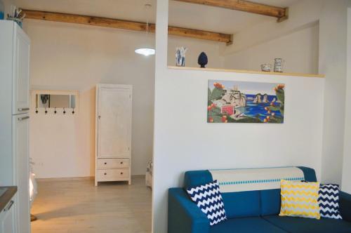 a living room with a blue couch in a room at Casa Teresa in Portoscuso