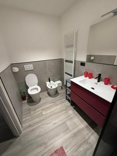 a bathroom with two sinks and a toilet and a mirror at Il Paese delle Vacanze in Omegna