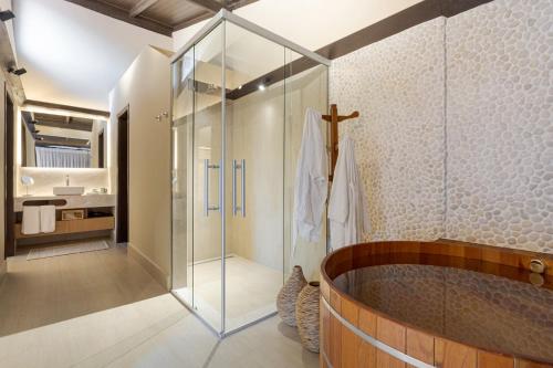 a bathroom with a glass shower and a tub at Pousada A Rosa e o Rei in São Francisco Xavier