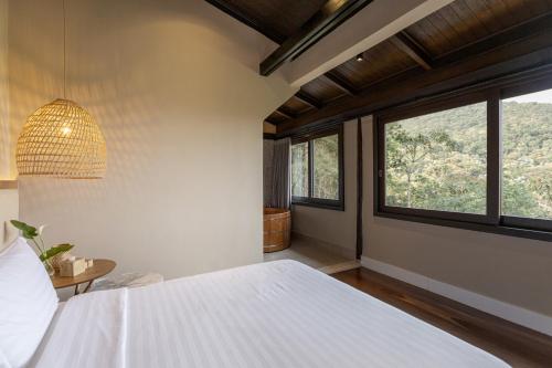 a bedroom with a white bed and a window at Pousada A Rosa e o Rei in São Francisco Xavier