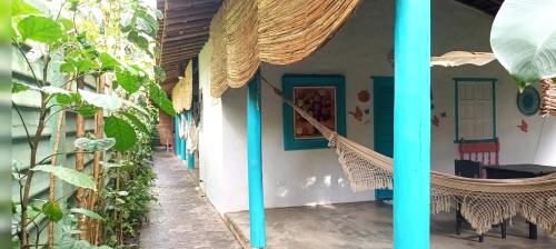 a house with blue columns and a porch with plants at 4eTal Trancoso EXCLUSIVO PARA MULHERES ONLY WOMEN in Trancoso
