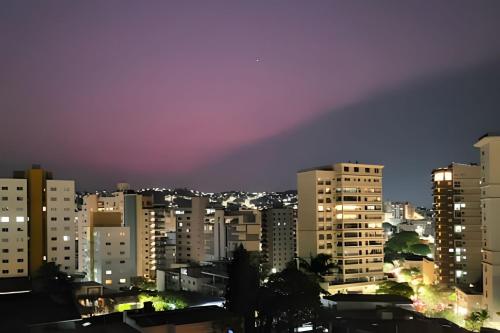 a city skyline at night with a rainbow at Residencial GO 305 - in Poços de Caldas