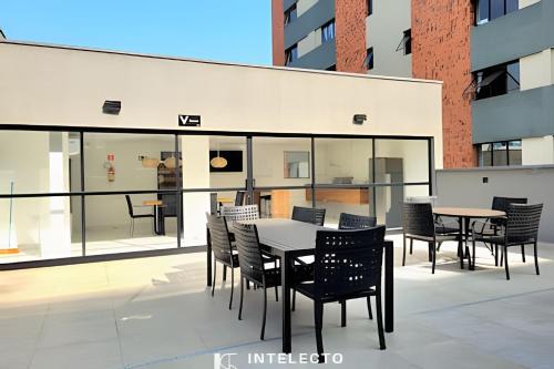 a patio with tables and chairs on a building at Residencial GO 305 - in Poços de Caldas